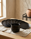 12 piece stoneware dinnerware service, empty plates fanned out with bowls stacked behind