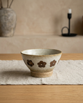 High footed rough pottery bowl, empty, on linen on a white oak table