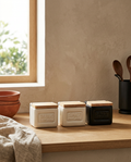 Ceramic kitchen canister set with bamboo lids, closed, on a white oak worktop